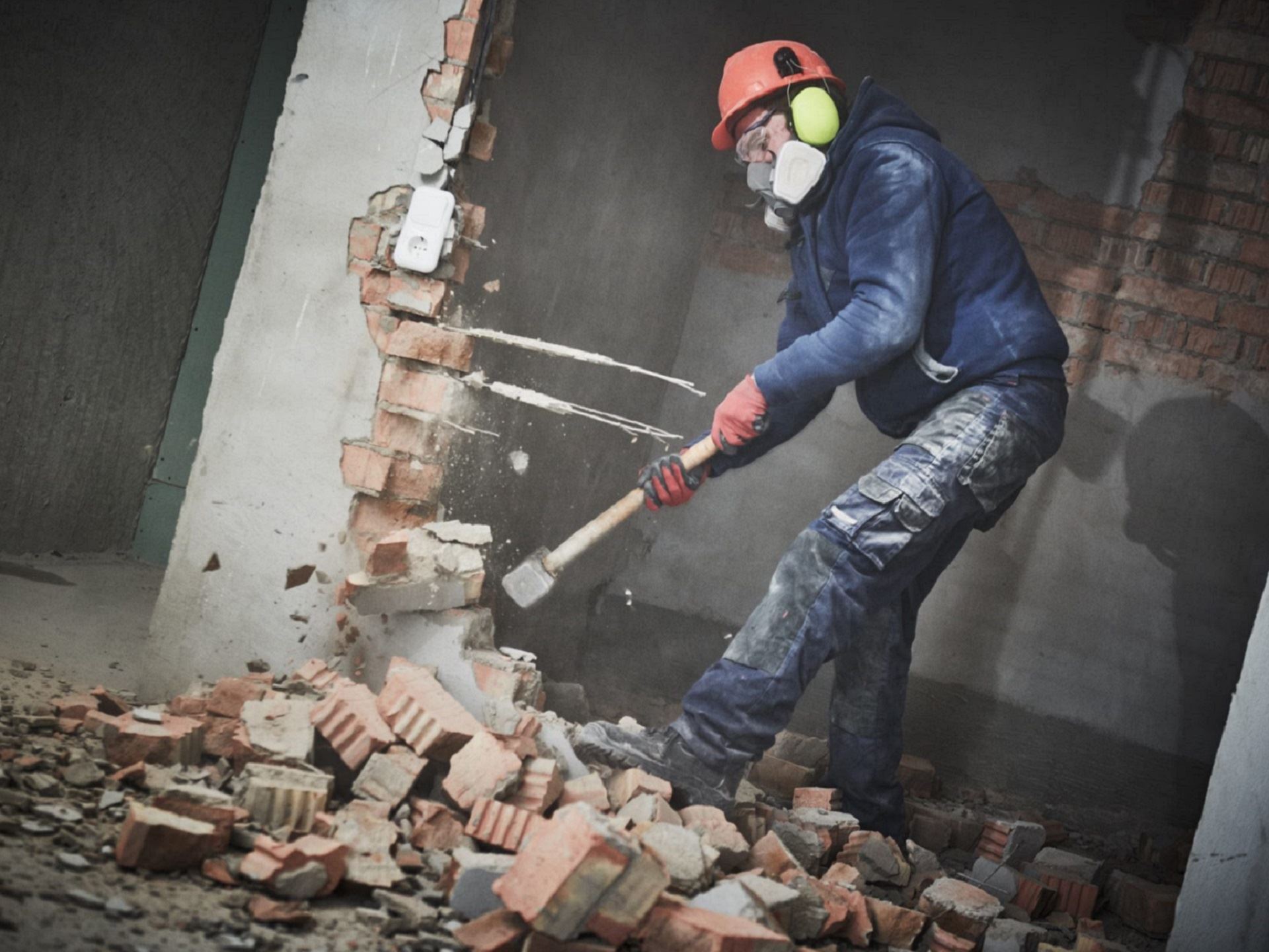 demolition work and rearrangement. worker with sledgehammer destroying wall